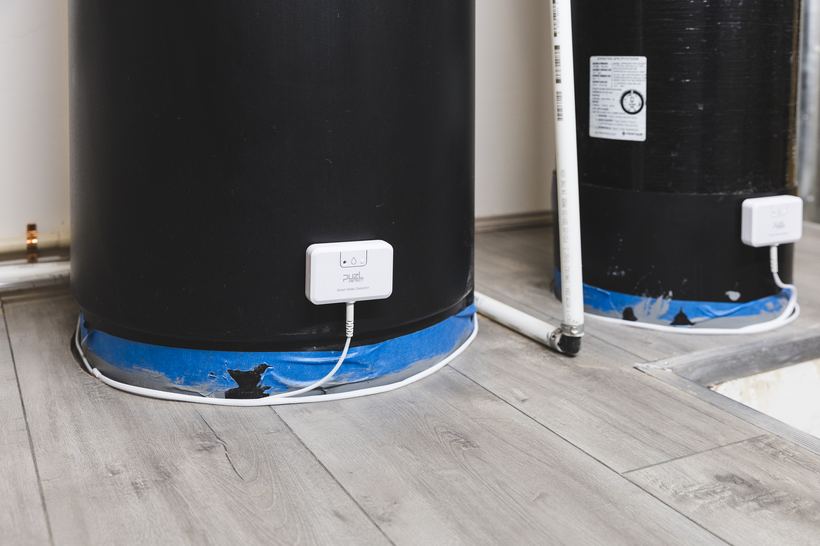 PuzL Detect units on two water softener tanks with cables around the bases