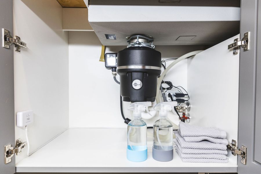 PuzL Detect mounted inside a sink cabinet with the cable routed around the plumbing
